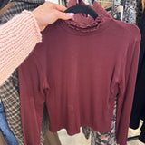 Burgundy cropped long sleeve mock turtleneck top with ruffle lettuce-edge collar on hanger