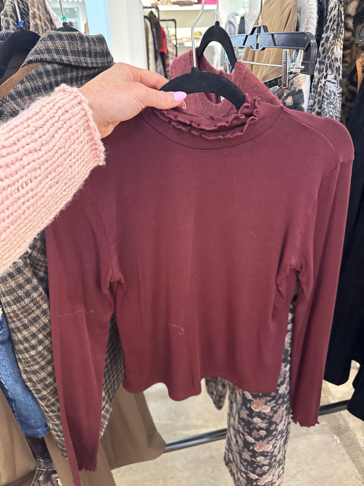 Burgundy cropped long sleeve mock turtleneck top with ruffle lettuce-edge collar on hanger