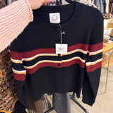 Black knitted cardigan with burgundy, white, and gold stripes, button-front, cropped fit on hanger