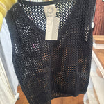 Black crochet knit sleeveless tank top with open weave pattern displayed on hanger