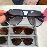 Navy blue DIFF aviator sunglasses with double bridge and gradient smoke lenses held up for display