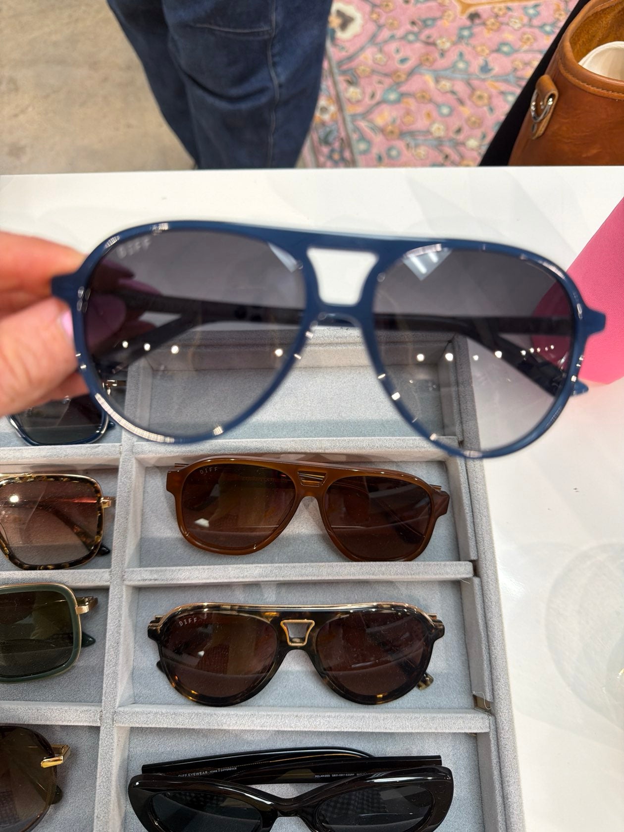 Navy blue DIFF aviator sunglasses with double bridge and gradient smoke lenses held up for display